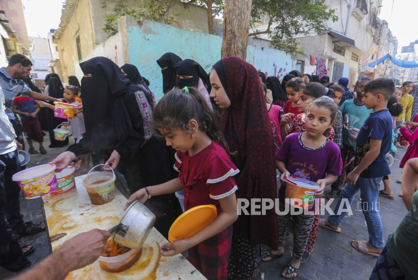 Warga Palestina menerima makanan di Rafah, Jalur Gaza selatan, Rabu (8/11/2023).