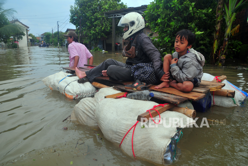 Sejumlah warga melintasi jalan yang terendam banjir dengan perahu rakit di Desa Setrokalangan, Kudus, Jawa Tengah, Jumat (15/3/2024). Menurut data BPBD setempat per Jumat 15/3, banjir akibat intensitas hujan yang tinggi di wilayah pegunungan Muria serta meluapnya sungai Wulan itu selain menyebabkan ribuan rumah terendam dan sebanyak 22.994 Jiwa terdampak serta sebanyak 271 Jiwa mengungsi di 20 Desa dari lima Kecamatan, juga menyebabkan empat orang meninggal akibat tenggelam. 