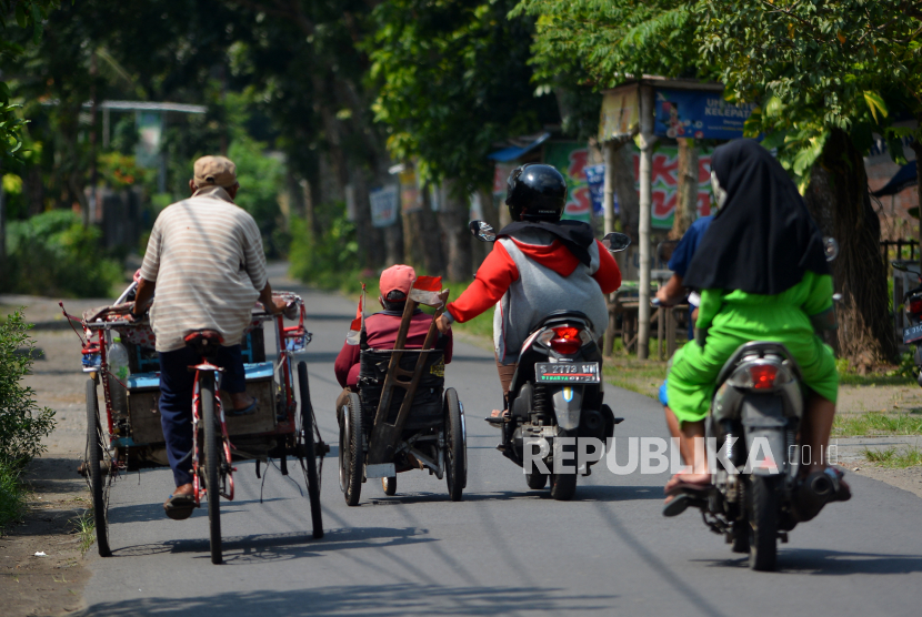 Seorang warga membantu mendorong sepeda roda tiga penyandang disabilitas yang melintas Jalan Raya Primono, Kabupaten Jombang, Jawa Timur, Sabtu (30/5/2020). Penyandang disabilitas merupakan salah satu kelompok masyarakat yang paling terdampak selama pandemi virus Corona (COVID-19)