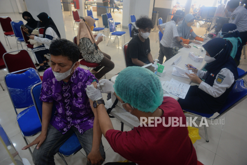 Petugas kesehatan menyuntikan vaksin Covid-19 kepada penumpang kereta di Stasiun Pasar Senen, Jakarta Pusat. Menkes: Kenaikan Kasus Covid-19 RI Mirip dengan India.