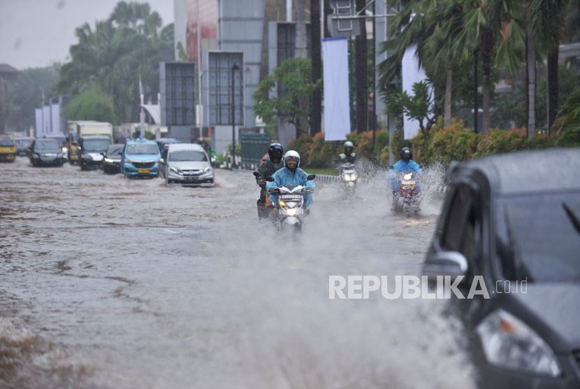 Kendaraan menerobos genangan air yang merendam di Jalan Boulevard Raya, Kelapa Gading, Jumat (22/3/2024). 