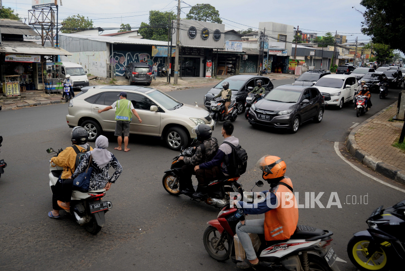 Petugas membantu kendaraan untuk berputar balik di Jalan Raya Pasar Minggu, Jakarta Selatan, Kamis (9/2/2023). Dinas Perhubungan DKI Jakarta berencana menutup 32 putaran balik (u-turn) di lima wilayah Jakarta untuk mengurai kemacetan.