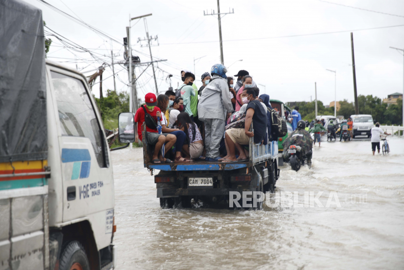 Warga mengendarai truk di jalan yang tergenang banjir di kota Cavite, Filipina. Pihak berwenang Filipina mengevakuasi puluhan ribu warga, karena Topan Rai telah mendarat di beberapa wilayah. Biro cuaca Filipina, PAGASA, mengatakan Topan Rai melakukan pendaratan pertamanya di Pulau Siargao Surigao del Norte pada Kamis (16/12), sekitar pukul 05:30 pagi waktu setempat.