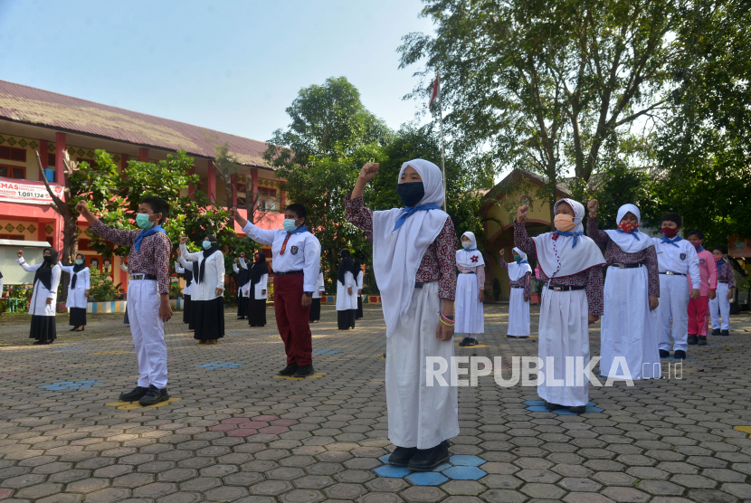 Sejumlah murid  mengacungkan tangan melakukan yel yel semangat menegakan disiplin prptokol kesehatan  saat pengukuhan sebagai Satgas COVID-19,  di Sekolah Dasar Negeri Meduarti Banda Aceh, Aceh, Rabu (3/2/2021). Pengukuhan Satgas COVID-19 yang beranggotakan sejumlah pelajar itu merupakan edukasi kepada murid serta membangun sinergitas dalam meningkatkan disiplin kesehatan di lingkungan sekolah untuk mencegah penyebaran COVID-19.