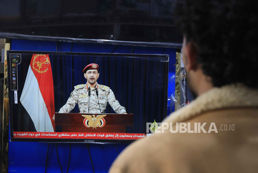 Seorang pria menyaksikan juru bicara militer Houthi Yahya Sarea menyampaikan pernyataan TV mengenai serangan kapal baru, di Sana.