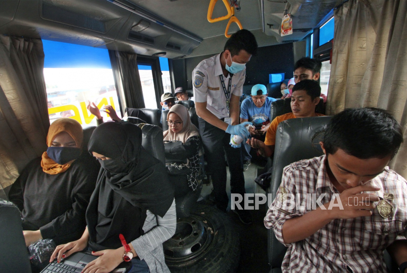 Petugas memberikan cairan antiseptik atau hand sanitizer kepada penumpang bus di terminal. Wali Kota Tasikmalaya Budi Budiman mengimbau warga Tasik tak pulang kampung. Ilustrasi.
