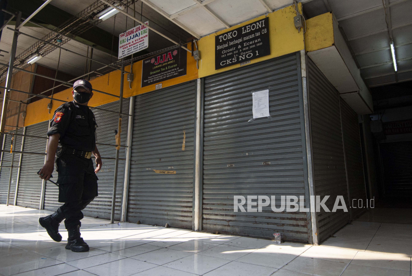 Petugas keamanan berpatroli di Blok VI Pasar Senen yang mayoritas tutup di Jakarta Pusat.