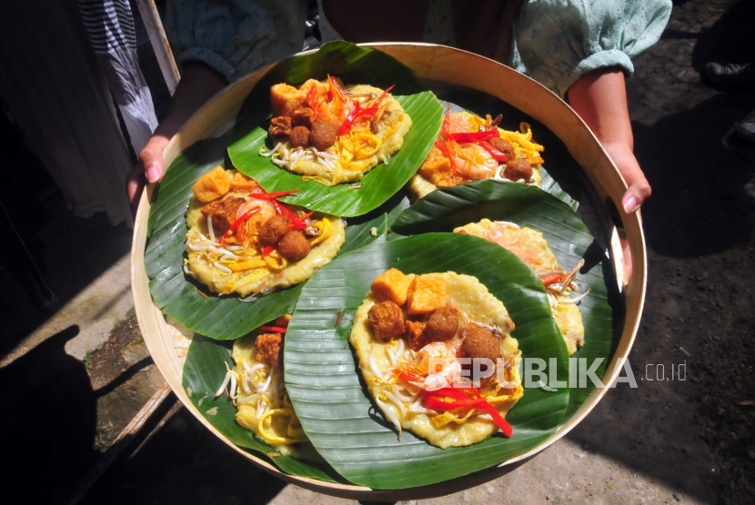 Warga berjalan membawa bubur asyura (ilustrasi). Bubur asyura menjadi salah satu kuliner tradisional yang sarat nilai sejarah dan makna religius bagi masyarakat Indonesia, khususnya umat Islam.