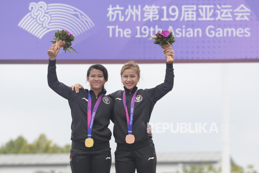 Dua pesepeda BMX Indonesia Amellya Nur Sifa (kiri) dan Jasmine Azzahra Setyobudi (kanan) berfoto bersama di atas podium usai berlomba pada final putri Asian Games 2022 di Chunan Jieshou Sports Centre BMX Course, China, Ahad (1/10/2023). Amellya meraih emas usai mencatatkan waktu 44,065 detik pada heat pertama, 43,290 detik pada heat kedua, dan 43,918 detik pada heat ketiga sedangkan Jasmine meraih perunggu usai mencatatkan waktu 45,244 detik, 43,551 detik, 43,956 detik. 