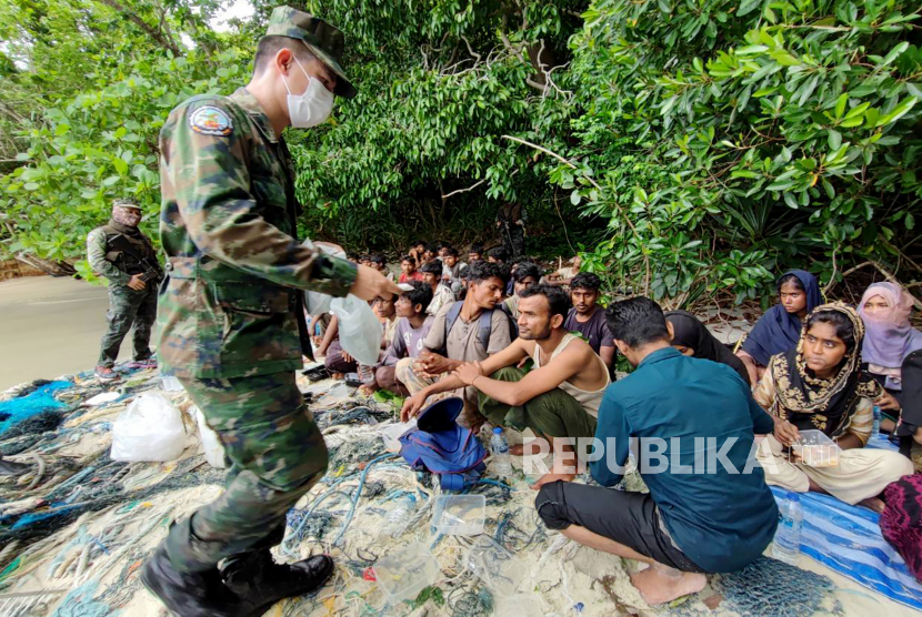  Foto selebaran yang dirilis oleh Angkatan Laut Kerajaan Thailand menunjukkan seorang tentara Thailand membantu pengungsi Rohingya setelah ditemukan di pulau Dong, dekat perbatasan Thailand-Malaysia di provinsi paling selatan Satun di Thailand, 04 Juni 2022 (dikeluarkan 05 Juni 2022).