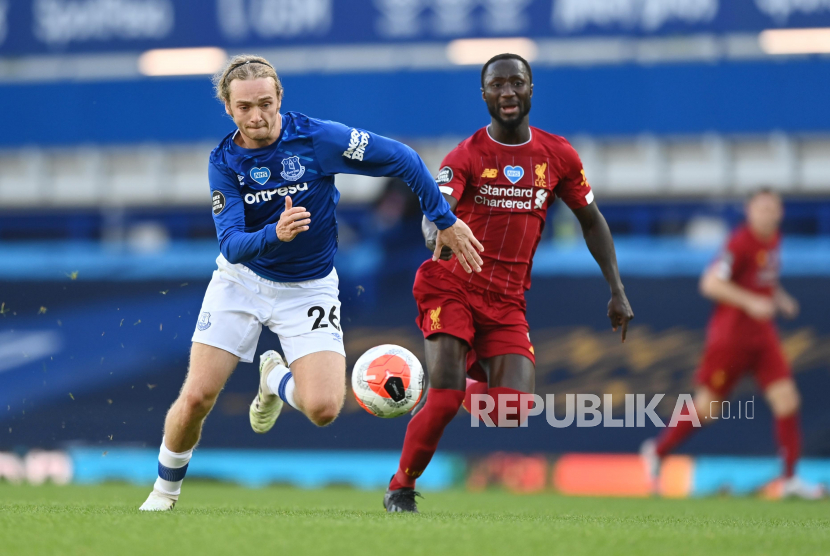 Pemain Everton Tom Davies (kiri) mengejar bola dengan kawalan gelandang Liverpool Naby Keita.