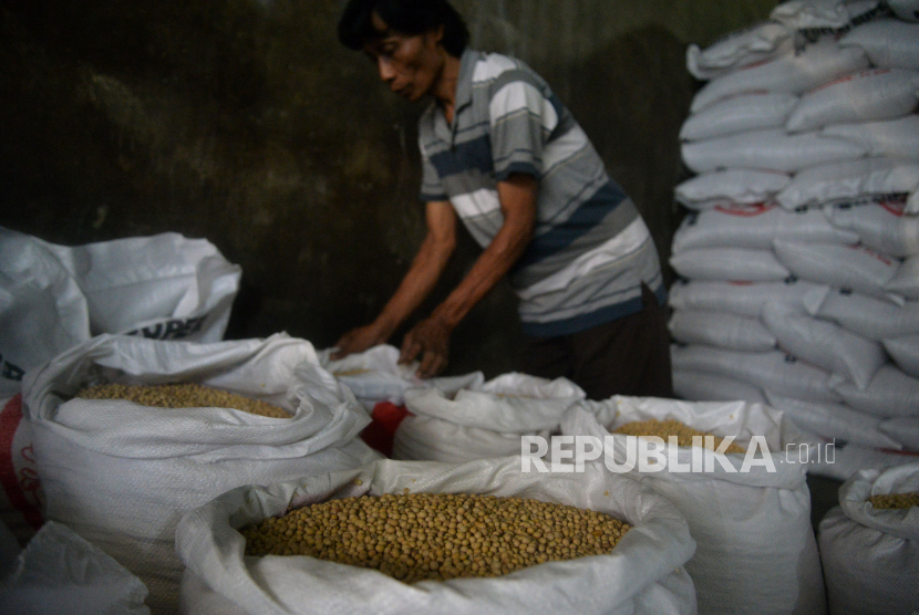 Pekerja memasukkan kacang kedelai ke dalam karung di Kawasan Duren Tiga, Jakarta, Selasa (26/7/2022). Badan Pusat Statistik (BPS) mencatat, mulai terjadi penurunan sejumlah harga komoditas pangan utama global yang diimpor Indonesia.
