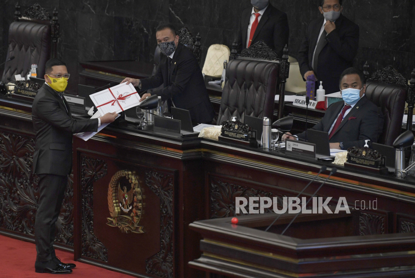 Ketua Komisi II DPR RI Ahmad Doli Kurnia Tanjung (kiri) menyerahkan dokumen UU Pilkada kepada Menteri Hukum dan HAM Yasonna Laoly (tengah) dan Mendagri Tito Karnavian (kanan) dalam Rapat Paripurna DPR ke-18 Masa Persidangan IV Tahun Sidang 2019-2020, di Kompleks Parlemen Senayan, Jakarta, Selasa (14/7/2020). DPR mengesahkan Rancangan Undang-Undang tentang Perppu Pilkada menjadi Undang-Undang. ANTARA FOTO/Puspa Perwitasari/hp.