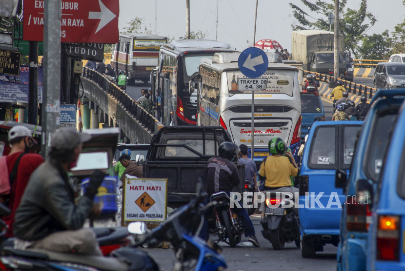 Sejumlah bus lintas provinsi parkir menunggu penumpang di terminal bayangan jembatan layang Cibinong, Kabupaten Bogor, Jawa Barat, Senin (31/8/2020). Keberadaan bus yang diparkir di jembatan layang dan pinggir jalan tersebut mengganggu arus lalu lintas. 