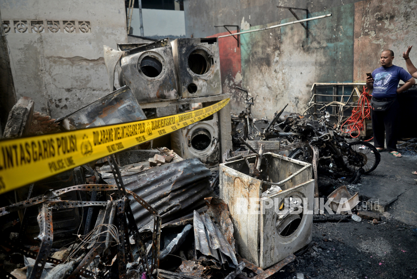 Warga melihat puing-puing rumah yang hangus terbakar di kawasan Kali Pasir, Kelurahan Cikini, Kecamatan Menteng, Jakarta, Sabtu (18/12). 