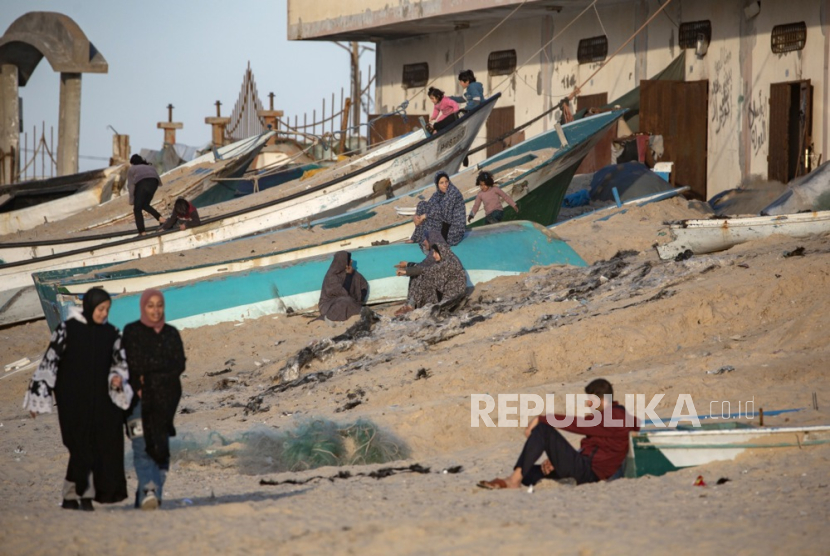 Warga Palestina di pantai saat matahari terbenam dekat kamp pengungsi Rafah, Jalur Gaza selatan, (11/12/2024).