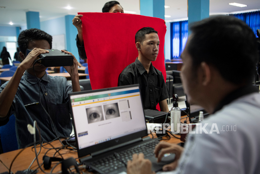 Petugas melakukan perekaman data biometrik mata saat pembuatan KTP elektronik bagi siswa di SMK Negeri 2 Palembang, Sumatera Selatan, Kamis (3/11/2022). Dinas Kependudukan dan Catatan Sipil (Disdukcapil) Kota Palembang melakukan perekaman KTP elektronik bagi siswa SMK dan sederajat dengan mendatangi langsung sejumlah sekolah untuk mempercepat dan memudahkan siswa yang telah berusia 17 tahun mendapatkan KTP elektronik. 