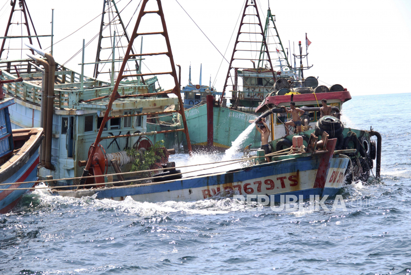 Pekerja membanjiri ruang kargo kapal berbendera Vietnam untuk menenggelamkannya di perairan Pulau Datuk, Kalimantan Barat, Indonesia, Sabtu, 4 Mei 2019, saat pihak berwenang menenggelamkan 51 kapal penangkap ikan asing yang tertangkap beroperasi secara ilegal di perairan Indonesia.