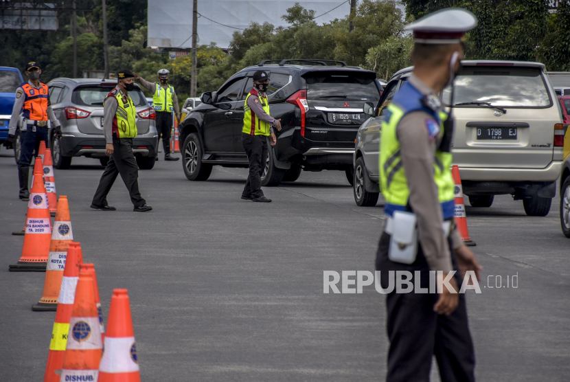 Petugas gabungan mengatur lalu lintas saat pemberlakuan ganjil genap di gerbang keluar Tol Pasteur, Kota Bandung.