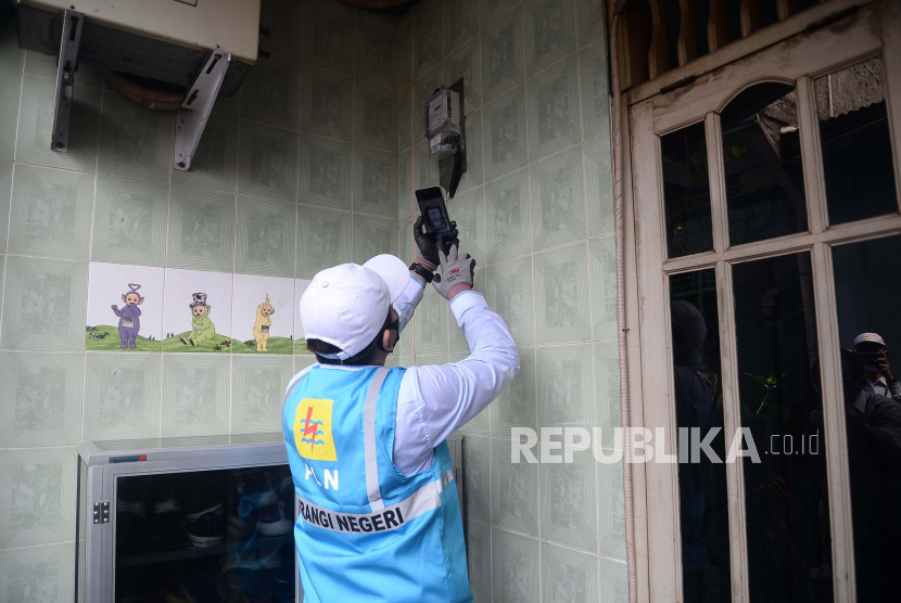 Petugas PLN melakukan pencatatan meter listrik secara langsung ke rumah pelanggan 
