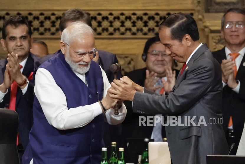 Perdana Menteri India Narendra Modi, kiri, memegang palu bersama Presiden Indonesia Joko Widodo saat upacara serah terima KTT Pemimpin G20, di Nusa Dua, Bali, Indonesia, Rabu, 16 November 2022.