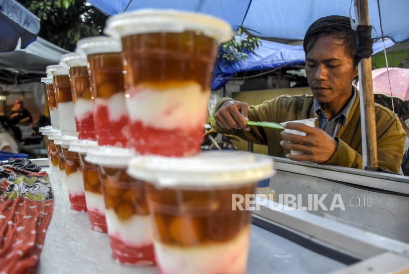 Pedagang melayani pembeli di Pasar Takjil Ramadhan di kawasan Masjid Pusdai, Kota Bandung, Ahad (3/4/2022). 