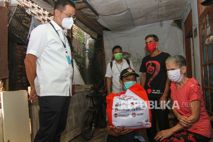 Menteri Sosial Juliari P Batubara (kiri) memberikan paket bantuan kepada warga terdampak Covid-19.
