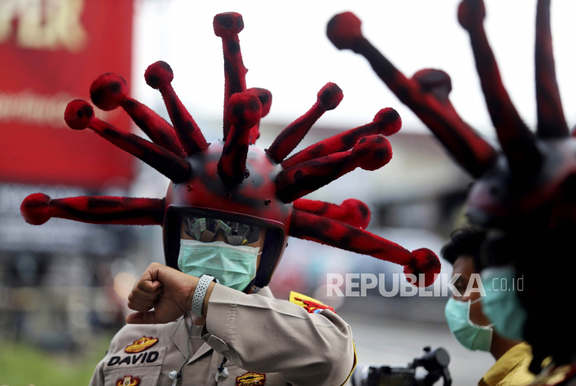 Orang tanpa gejala Covid-19, jumlahnya semakin bertambah. Foto seorang perwira polisi Indonesia yang memakai helm yang dimodifikasi menyerupai coronavirus.