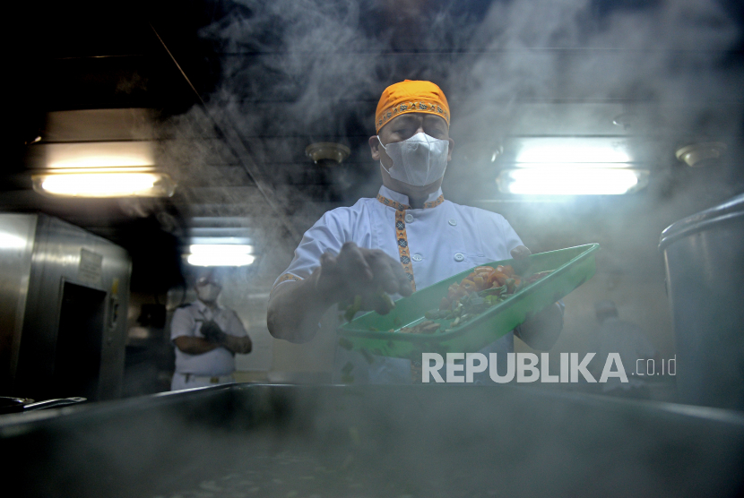 Juru masak  dengan menggunakan masker menyaipakan makanan di atas  KM Dorolonda di Pelabuhan Tanjung Priok, Jakarta, Ahad (15/11). 