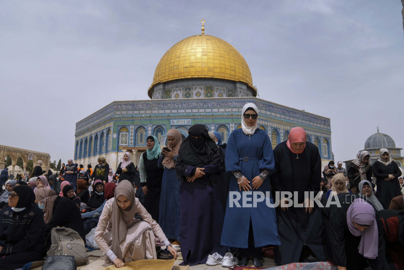 Wanita Palestina berdoa di depan kuil Dome of the Rock di kompleks Masjid Al Aqsa di kota tua Yerusalem. Yordania pada Ahad (22/5/2022) mengecam putusan pengadilan Israel yang memungkinkan 
