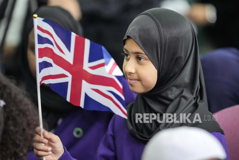  Seorang gadis Muslimah  mengibarkan bendera Inggris dalam peringatan Muslim nasional untuk mendiang Ratu Elizabeth II di Masjid Pusat London, Inggris, Kamis, (15/9/2022). 