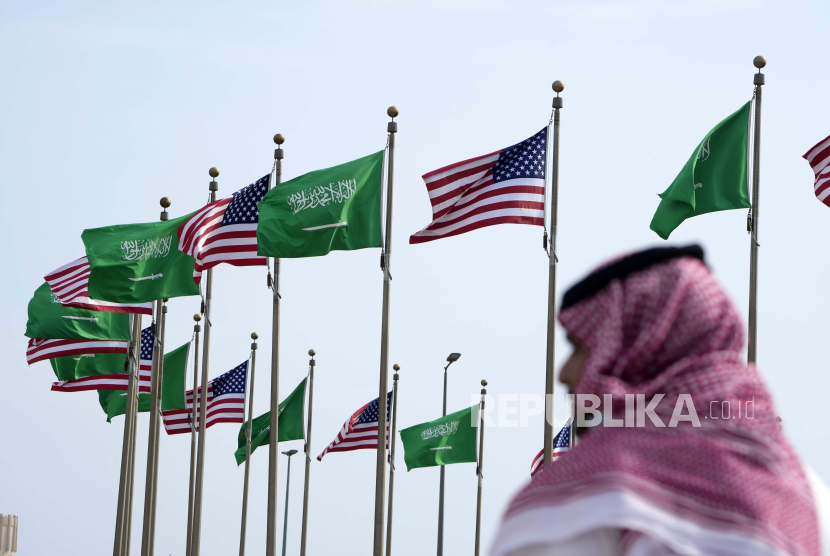 Seorang pria berdiri di bawah bendera Amerika dan Arab Saudi (ilustrasi). Arab Saudi memilih Amerika Serikat (AS) sebagai mitra dalam proses pengembangan program nuklir sipil.