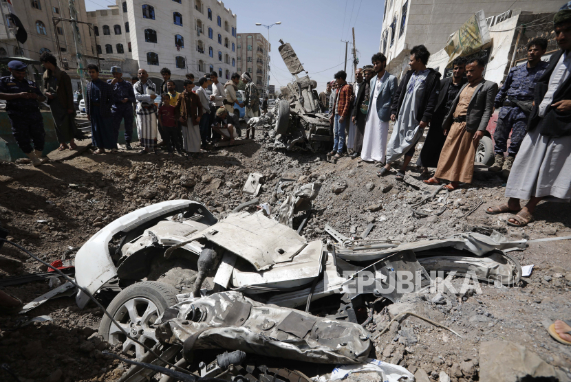 Warga Yaman memeriksa lokasi serangan udara pimpinan Saudi yang menargetkan posisi di Sana