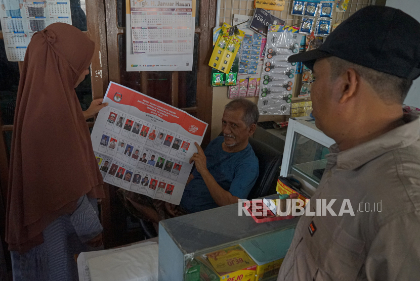 Jakfar (tengah) seorang warga Gampong Jawa yang menderita lumpuh harus dibantu anaknya untuk melakukan pencobolosan dalam pemungutan suara Pemilu 2024 di rumahnya, Banda Aceh, Aceh, Rabu (14/2/2024). Panitia Pemungutan Suara menerapkan pencoblosan sistem jemput suara ke rumah-rumah bagi para pemilih yang tidak bisa hadir ke Tempat Pemungutan Suara (TPS) untuk mencoblos karena sakit. 
