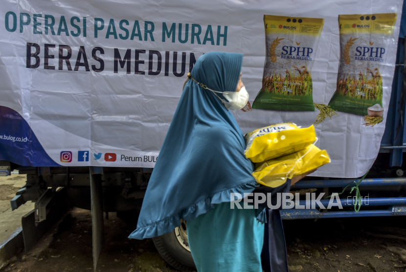 Warga membawa beras kualitas medium saat operasi pasar beras medium di Lapangan Gasmin, Jalan Purwakarta, Antapani, Kota Bandung, Jawa Barat, Rabu (22/2/2023). Kemendag mencatat, terdapat empat komoditas pangan yang rentan melonjak.