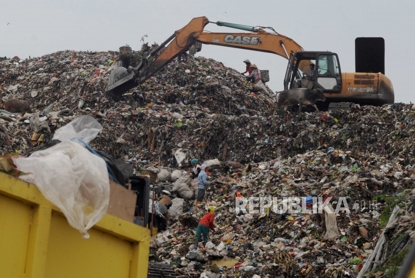 Aktivitas sejumlah pemulung dan alat berat di Tempat Pembuangan Akhir (TPA) Sukawinatan Palembang, Sumatera Selatan, Rabu (30/6/2021). Sejak diberlakukannya PKM skala mikro yang membuat tempat tempat umum tutup lebih awal, UPTD TPA Sukawinatan Palembang mencatat terjadi penurunan hampir 50 ton sampah dari jumlah sampah rata rata per hari 850 ton. 