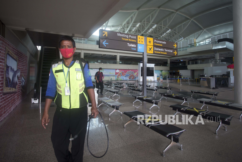 Seorang pekerja bandara berjalan di aula kedatangan Bandara Internasional Ngurah Rai di Bali, Indonesia, Kamis, 14 Oktober 2021.