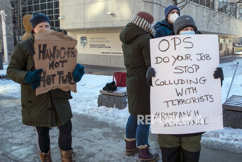 Orang-orang berkumpul di luar kantor polisi di Ottawa, Ontario, Kanada, pada hari Minggu, 13 Februari 2022, menuntut pihak berwenang menurunkan pengemudi truk dan pengunjuk rasa lainnya yang telah mengambil alih area di sekitar Parliament Hill untuk berdemonstrasi menentang pembatasan COVID-19. 