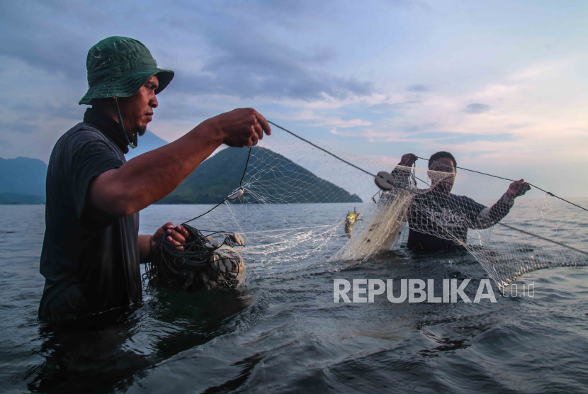 Dua nelayan menarik alat tangkap tradisional jaring pukat darat saat mencari ikan di pesisir Pantai Kalumata, Kota Ternate, Maluku Utara, Jumat (1/12/2023). 