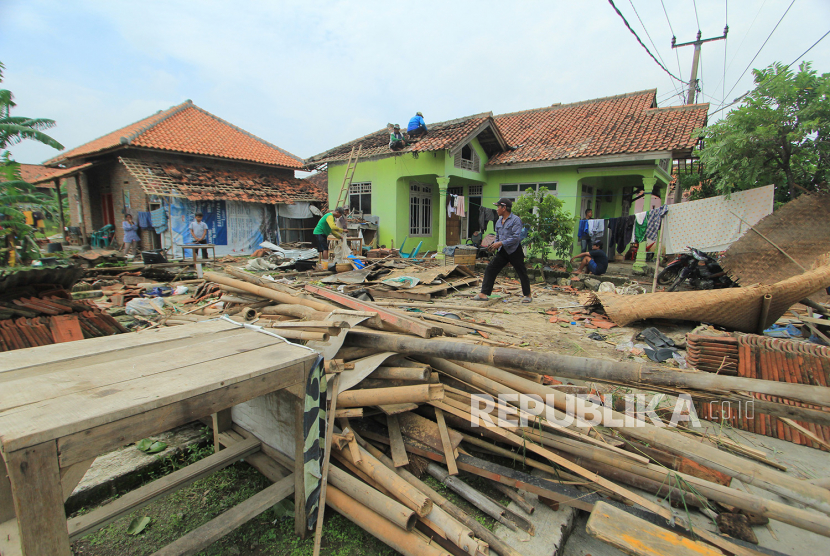Sejumlah warga memperbaiki rumah yang rusak akibat angin puting beliung di desa Slangit, Kecamatan Klangenan, Kabupaten Cirebon, Jawa Barat, Ahad (3/1/2021). Angin puting beliung yang terjadi pada Sabtu (2/1) sore itu menyebabkan sedikitnya 275 rumah warga mengalami kerusakan. 