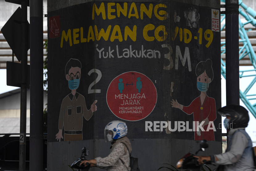 Pengendara motor melintas di depan mural tentang Covid-19 di Jakarta, Ahad (10/10). Kondisi pandemi Covid-19 di Indonesia saat ini tengah berada pada tren penurunan. (ilustrasi)