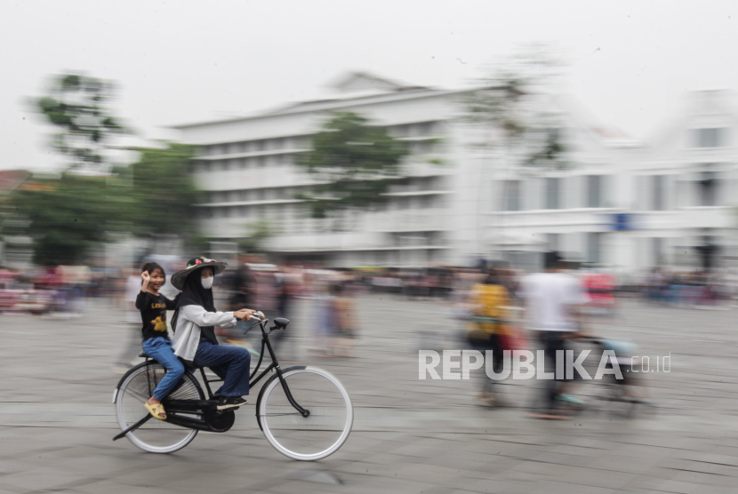 Sejumlah warga bersepeda saat berwisata di kawasan Kota Tua, Jakarta, Selasa (26/12/2023). 