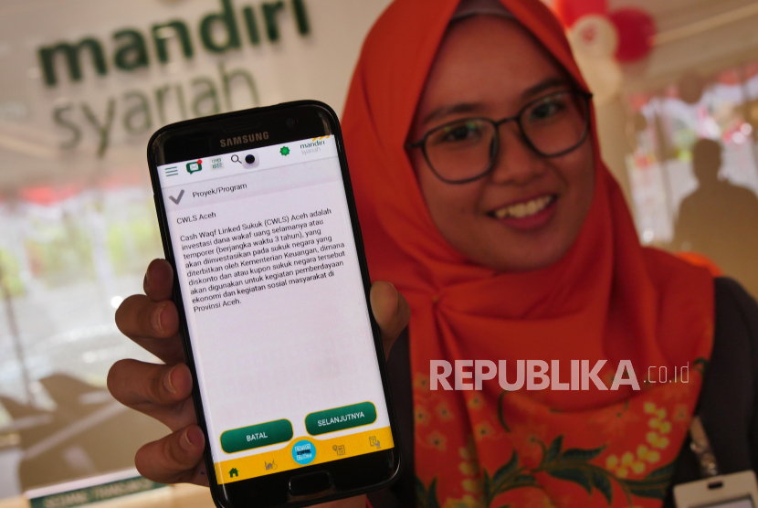 Pegawai Mandiri Syariah tengah menunjukkan fitur wakaf sukuk CWLS Aceh pada dashboard aplikasi Mandiri Syariah Mobile,  di Jakarta, Senin (31/8). Hingga awal November 2020, Mandiri Syariah telah mencatatkan partisipasi dari kurang lebih 900 wakif