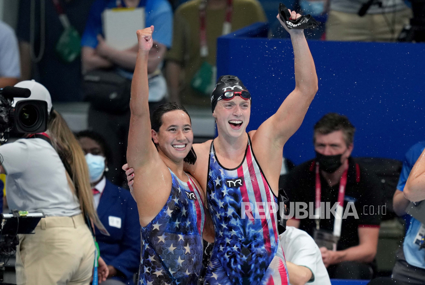 Perenang putri Amerika Serikat Katie Ledecky berselebrasi bersama rekan senegaranya, Erica Sullivan (kiri), setelah meraih medali emas Olimpiade Tokyo di kelas gaya bebas 1500 meter, Rabu (28/7). 