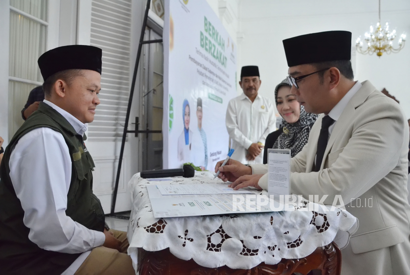 Gubernur Jawa Barat (Jabar) Ridwan Kamil menyalurkan zakat melalui Badan Amil Zakat Nasional (Baznas) saat acara Berkah Zakat di Gedung Pakuan, Kota Bandung, Jabar, Senin (10/4/2023). 