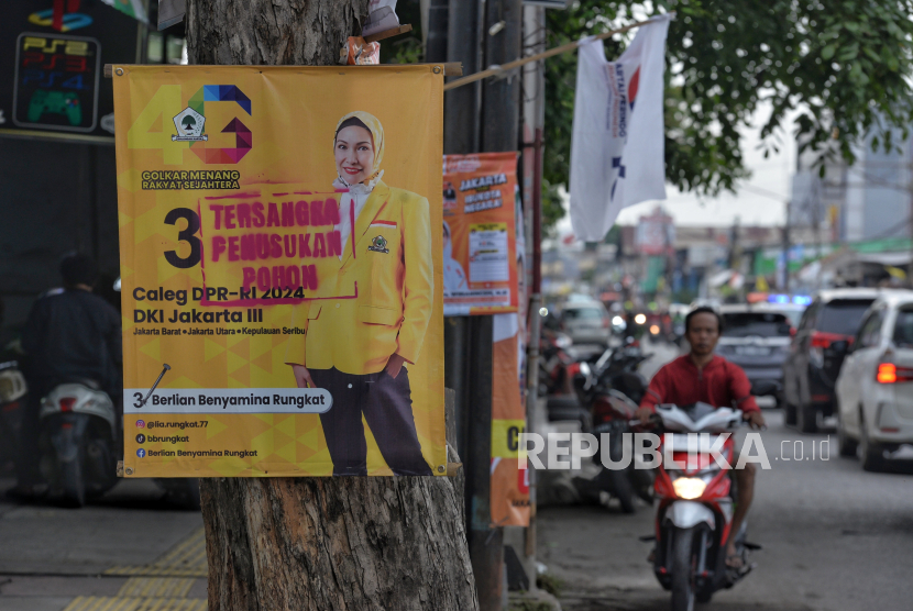 Warga melintas di dekat poster caleg yang dicoret tulisan tersangka penusukan pohon di Kawasan Plumpang, Jakarta Utara, Senin (15/1/2024). Pelabelan yang dilakukan oleh orang yang tidak dikenal itu sebagai bentuk protes atas pemasangan alat peraga kampanye caleg dengan memaku pohon yang melanggar Peraturan KPU (PKPU) Nomor 15 Tahun 2023 tentang Kampanye Pemilu 2024 pasal 70 huruf H.