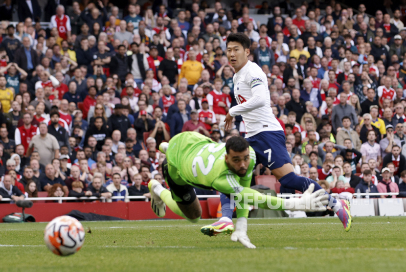 Son Heung-min dari Tottenham mencetak gol kedua timnya melewati kiper Arsenal David Raya saat pertandingan sepak bola Liga Premier Inggris antara Arsenal dan Tottenham Hotspur di stadion Emirates di London, Inggris, Ahad, (24/9/2023).