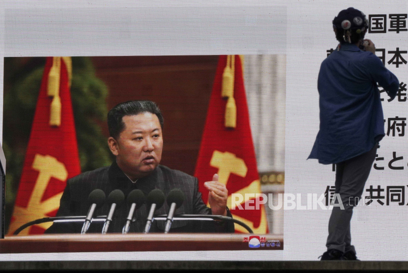 Seorang pejalan kaki menonton layar besar, menampilkan berita TV yang melaporkan peluncuran rudal balistik Korea Utara lainnya dengan foto pemimpinnya Kim Jon-un, di Tokyo, Jepang, 28 September 2021. 