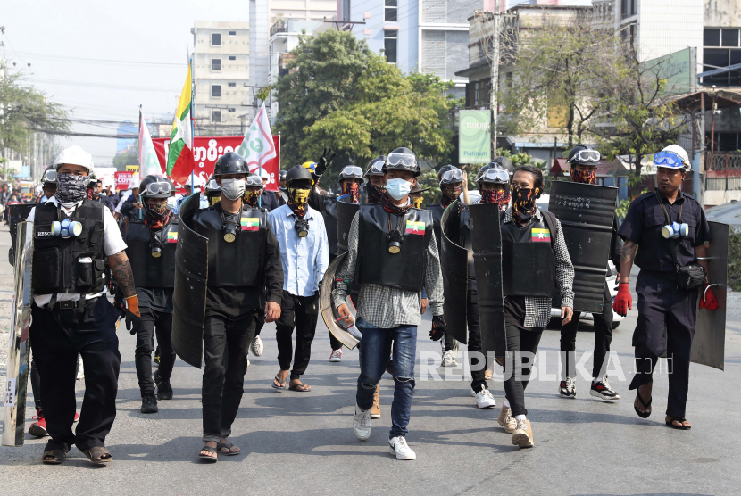  Pengunjuk rasa anti-kudeta berbaris dengan perisai darurat selama demonstrasi di Mandalay, Myanmar, Jumat, 12 Maret 2021. 