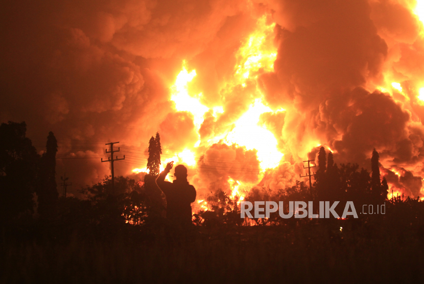 Warga mengambil video dengan gawai miliknya saat terjadi kebakaran di kompleks Pertamina RU VI Balongan, Indramayu, Jawa Barat, Senin (29/3/2021) dini hari. ANTARA FOTO/Dedhez Anggara/pras.